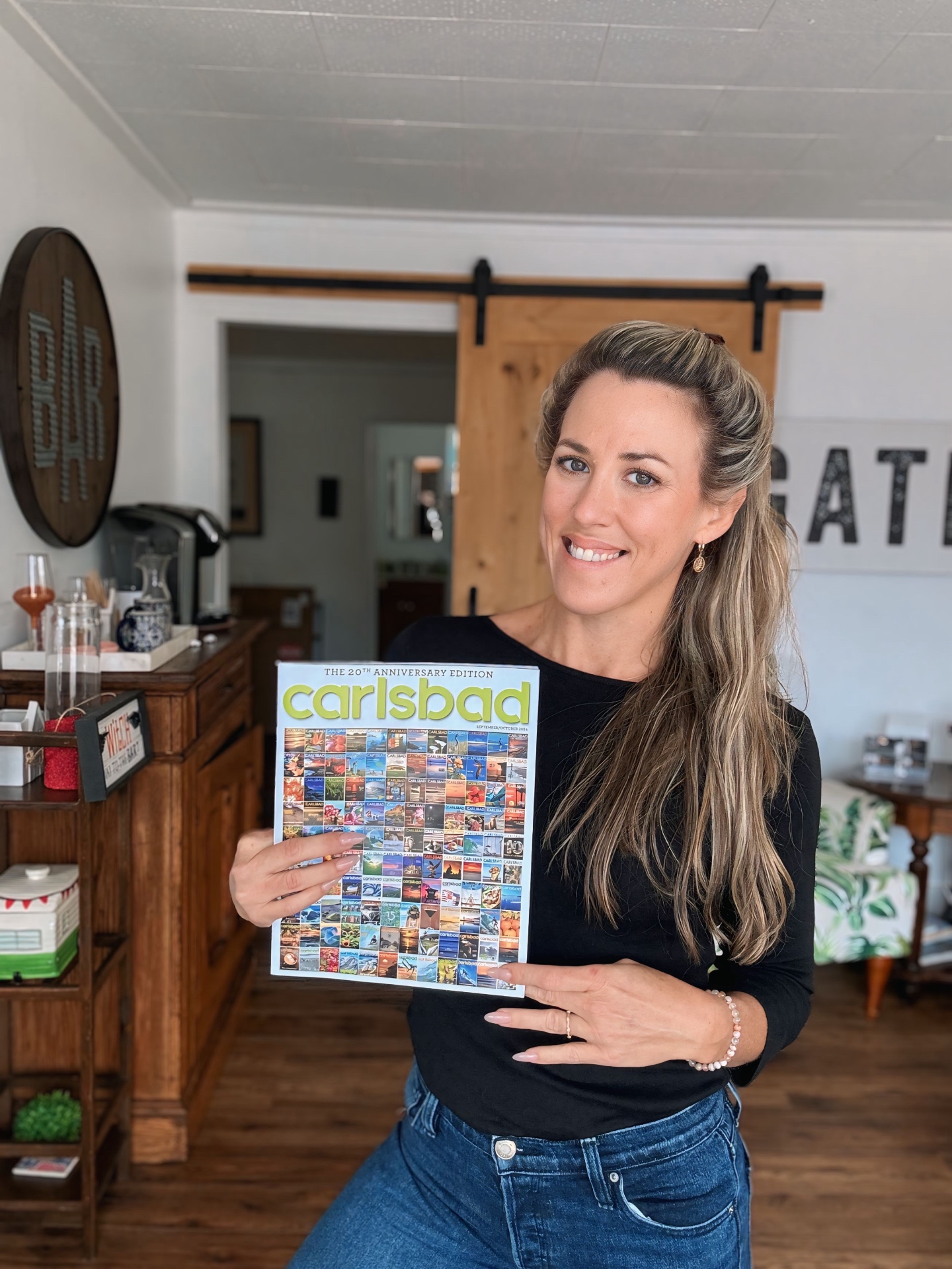 Founder of Namaste Anywhere™ holding a Carlsbad Magazine, rooted in the California coastal community
